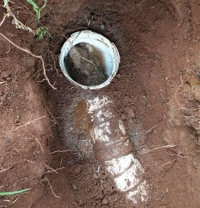 Underground drainage pipe inspection with cleanout access point.
